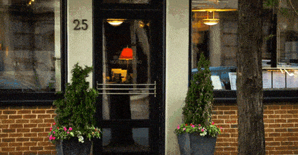 A flower pot adorned black door in Massachusetts.