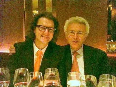 Two men posing euphorically with glasses of 2009 Beaujolais wine from Georges Duboeuf, a renowned wine producer.