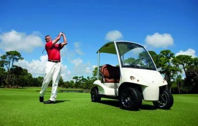 A man is driving a luxurious golf cart on a golf course to surprise golfers.