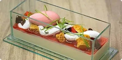 A dessert in a glass dish with strawberries and cream, served at a UK Pub Grub.