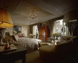 A luxurious bedroom with an imperial bed and a chandelier.