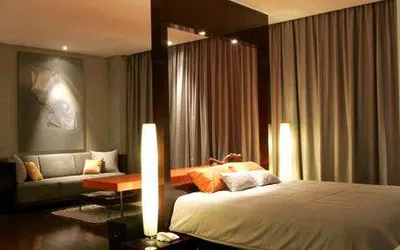 A quiet bedroom with a bed and a couch at Kemang Icon.