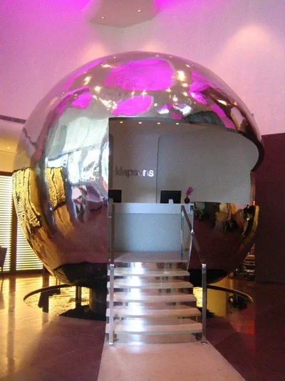 A large metal ball in the lobby of a hotel promises an exclusive stay in Singapore.