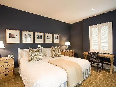 A bedroom with blue walls and a white bed in Fairway Homes at Millbrook Resort Hotel.