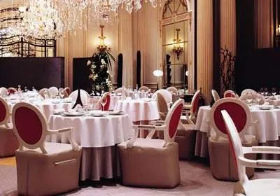 A large dining room with luxurious white tables and chairs.
