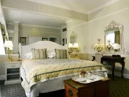 A luxurious bedroom with a large bed and a large mirror, nestled within nature.
