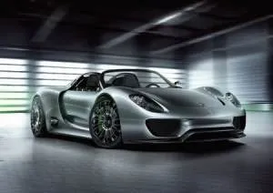 The Porsche 918 Spyder is showcased in a dimly lit room.