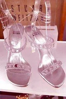 A pair of silver Cinderella slippers on display in a display case.
