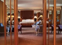 A luxurious retreat at the heart of Geneva, with a bed, chairs and mirrors.