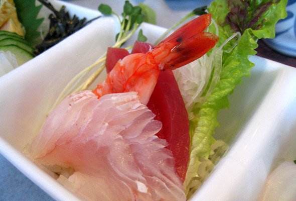 Japanese food with shrimp and vegetables served in a white bowl.