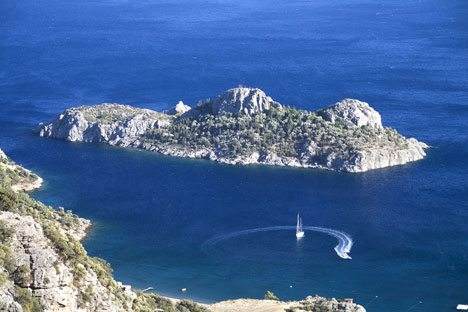 An exotic, private island holiday with a sailboat in the water.