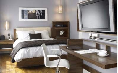 A bedroom with a desk and TV in a natural and eco-friendly environment at Duana Street Hotel.