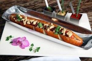 A hot dog sitting on a plate, making people aware of poverty.