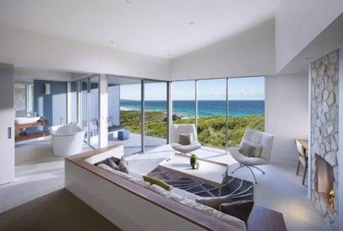 Experience teddy-friendly luxury at eco-resort Southern Ocean Lodge, showcasing a living room with an ocean view.
