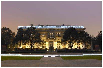 A grand mansion illuminated at night.