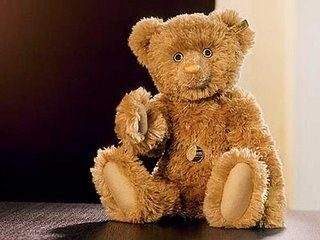 A teddy bear worth $193,000 sitting on top of a table.