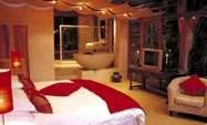 A bedroom with a bed and a bedside table.