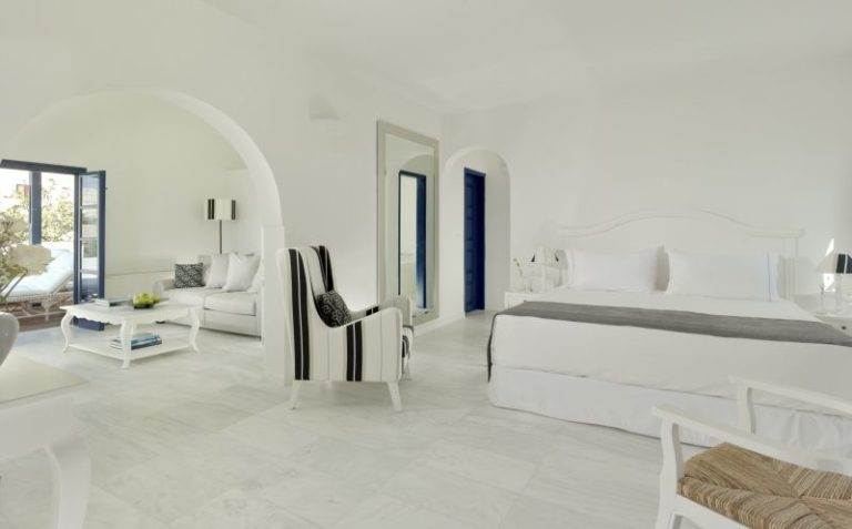 Get a visual feast of a white bedroom with a bed and a balcony at Vedama Resort.